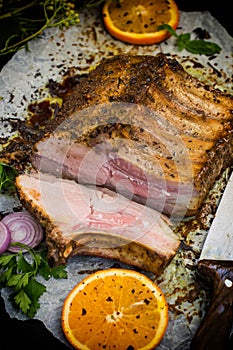 Baked pork ribs with sauce and basil on a black table. Top view. Close-up. Selective focus