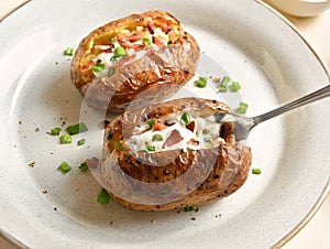 Baked potato with bacon, sour cream and green onion