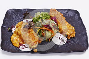 Baked potato with bake beans and sour cream, along with mixed lettuce leaves