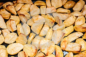 Baked potato slices on a baking sheet