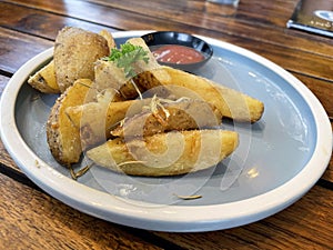 Baked potato wedges with shredded onion and herbs and tomato sauce