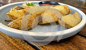 Baked potato wedges with shredded onion and herbs and tomato sauce