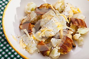 Baked potatoes with cauliflower, bacon, cheese sauce