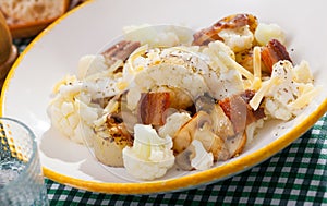 Baked potatoes with cauliflower, bacon, cheese sauce