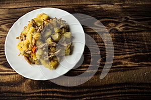 Baked potatoes with meat, carrots and onions