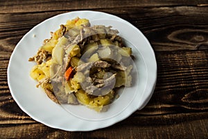 Baked potatoes with meat, carrots and onions
