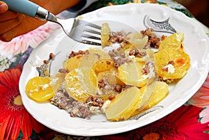 Baked potatoes with meat in plate