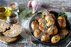 Baked potatoes in a peel in a cast-iron skillet. Rustic potatoes. Selective focus. Macro.