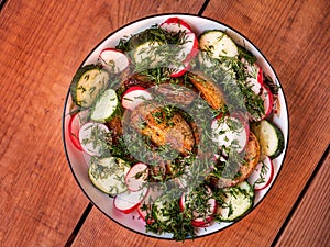 Baked potatoes with vegetables and dill on a colored plate