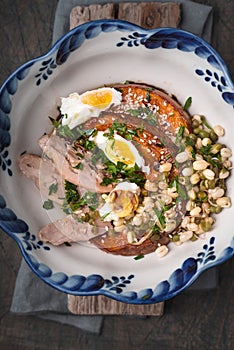 Baked pumpkin with chicken and eggs on the wooden background top view