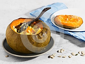 Baked pumpkin with porridge. Pumpkin is filled with cereals and milk. Organic food. Milk, corn grits, raisins, seeds. Natural