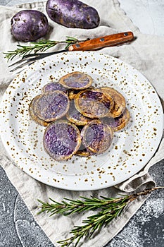 Baked purple potatoes with pink salt. Gray background. Top view