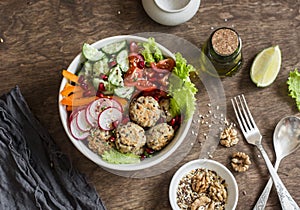 Baked quinoa meatballs and vegetable salad on a wooden table, top view. Buddha bowl. Healthy, diet, vegetarian food concept.