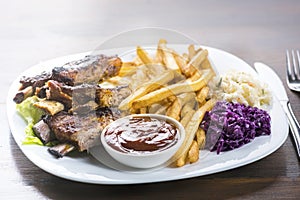 Baked ribs and French fries and cabbage salad