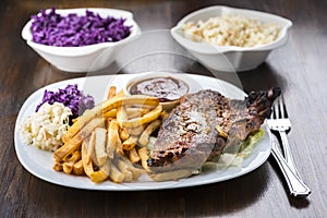 Baked ribs and French fries and cabbage salad