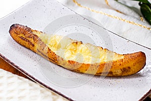 Baked Ripe Plantains with Cheese (Plantain Canoe or Platanos Asados Con Queso) on a plate