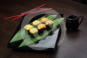 Baked rolls on the board with sauce and red chopsticks