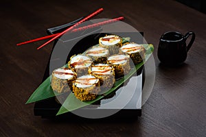 Baked rolls on the board with sauce and red chopsticks