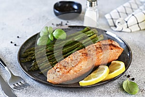 Baked salmon with asparagus for dinner. Concrete background