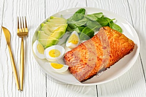 Baked salmon fillet with eggs , spinach, avocado