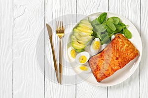 Baked salmon fillet with eggs , spinach, avocado
