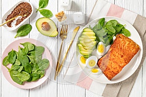 Baked salmon fillet with eggs , spinach, avocado