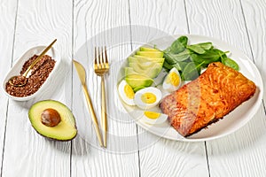 Baked salmon fillet with eggs , spinach, avocado