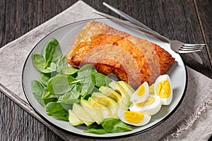 Baked salmon fillet with eggs , spinach, avocado