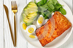 Baked salmon fillet with eggs , spinach, avocado