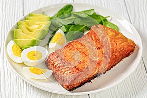 Baked salmon fillet with eggs , spinach, avocado
