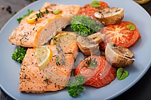 Baked salmon fish fillet with tomatoes, mushrooms and spices.