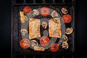 Baked salmon fish fillet with tomatoes, mushrooms and spices.