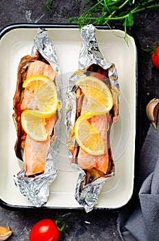 Baked Salmon in Foil, Cooked Fish with Vegetables in a baking dish on Bright Backround, Healthy Eating