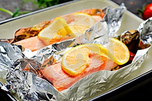 Baked Salmon in Foil, Cooked Fish with Vegetables in a baking dish on Bright Backround, Healthy Eating