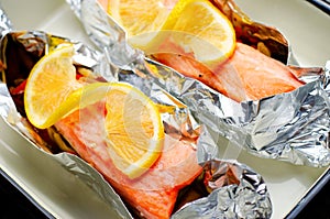 Baked Salmon in Foil, Cooked Fish with Vegetables in a baking dish on Bright Backround, Healthy Eating