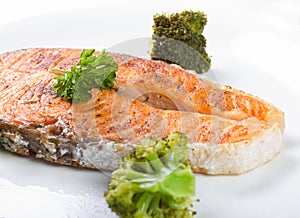 Baked salmon with fresh green broccoli on plate