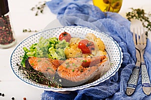 Baked salmon steak with cauliflower, tomatoes and herbs.