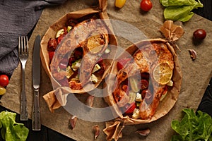 Baked salmon with vegetables on a dark background