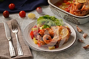 Baked salmon with vegetables on a gray background