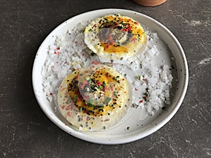 Baked scallops and cheese topped with yellow chili sauce and crispy quinoa.