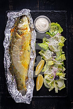 Baked sea bass and green salad. Healthy eating. Keto, ketogenic diet.