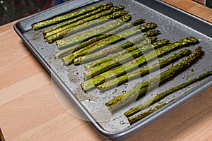 Baked seasoned asparagus on baking sheet