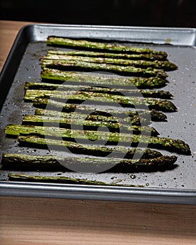 Baked seasoned asparagus on baking sheet