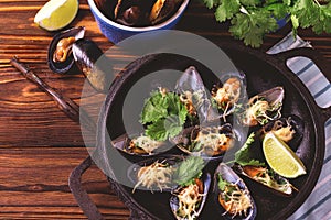 Baked shellfish mussels with cheese, cilantro and lime