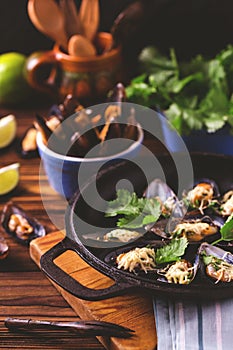 Baked shellfish mussels with cheese, cilantro and lime