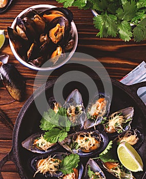 Baked shellfish mussels with cheese, cilantro and lime