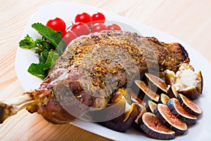 Baked shoulder of mutton with figs, tomatoes, soft cheese