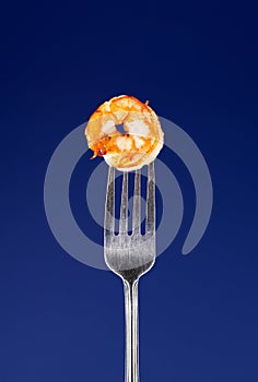 Baked shrimp on a fork isolated on a blue background, grilled shrimp on a fork. Poster for a restaurant