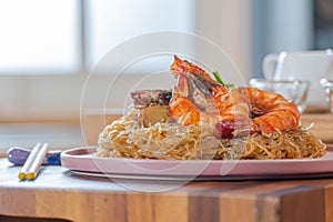 Baked Shrimp with Glass Noodles, a traditional Thai food wrapped in heat-treated freud paper and chopsticks, ready to serve-eat