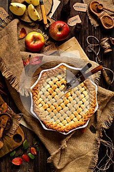 Baked sliced apple lattice pie crust on sackcloth on rustic wooden table